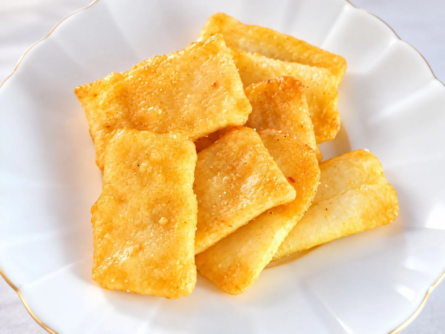 白いお皿に盛り付けた焼き色のついた米菓
